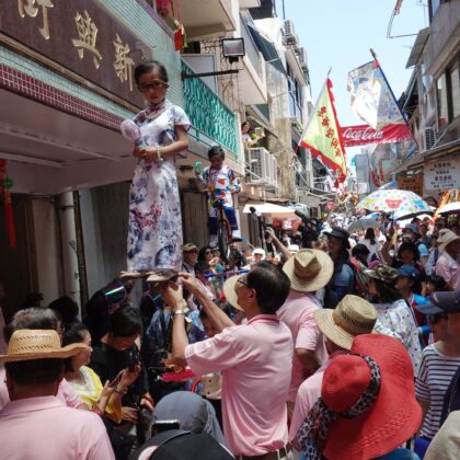 Cheung Chau Bun Festival Piu Sik Parade little girl dressed as a deity propped up on stilts