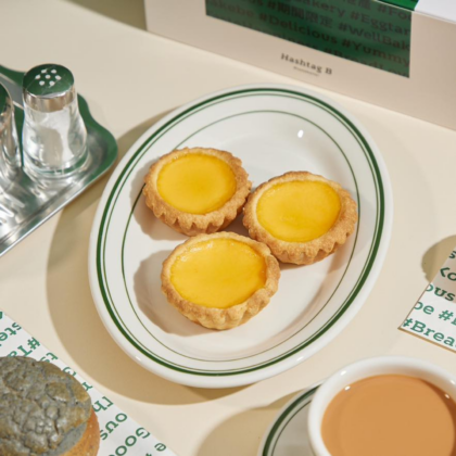 The Best Egg Tarts In Hong Kong three egg tarts laid out nicely on an oval plate